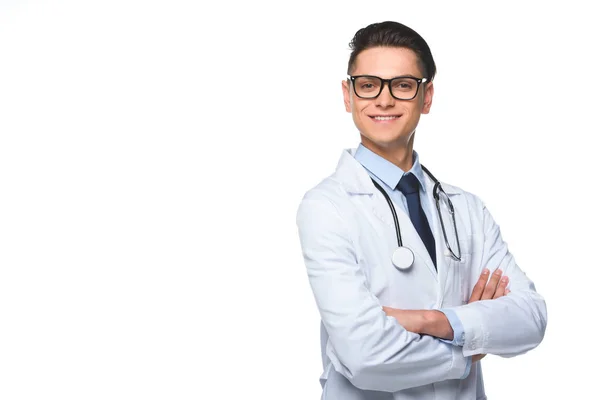 Jeune médecin masculin en manteau blanc avec stéthoscope posant avec les bras croisés, isolé sur blanc — Photo de stock