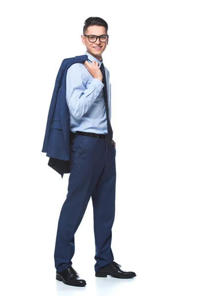 Feliz joven hombre de negocios caminando con chaqueta en el hombro y mirando a la cámara aislada en blanco - foto de stock