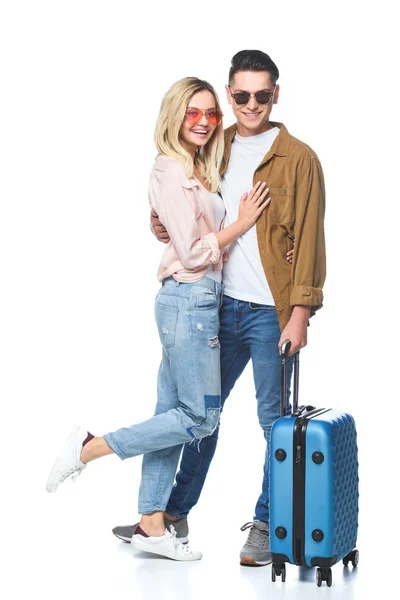Hermosa mujer joven abrazando a su novio mientras él de pie con la maleta aislada en blanco - foto de stock