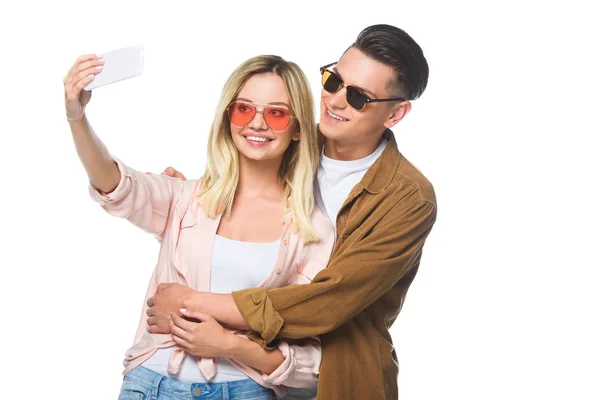 Feliz jovem casal tomando selfie com smartphone isolado no branco — Fotografia de Stock