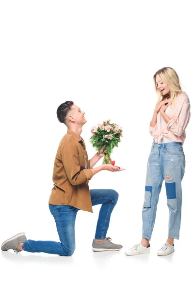 Вид збоку щасливий молодий чоловік робить пропозицію подрузі ізольовано на білому — стокове фото