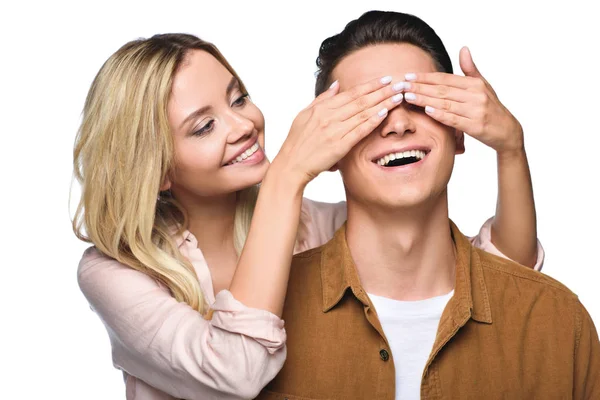 Feliz joven mujer cubriendo sus novios ojos por detrás aislado en blanco - foto de stock
