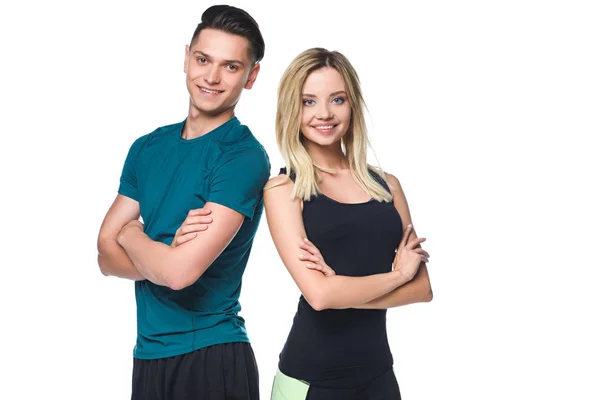Young sporty couple with crossed arms looking at camera isolated on white — Stock Photo