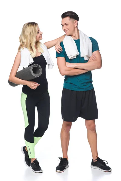 Young sporty couple with towels on shoulders and yoga mat isolated on white — Stock Photo