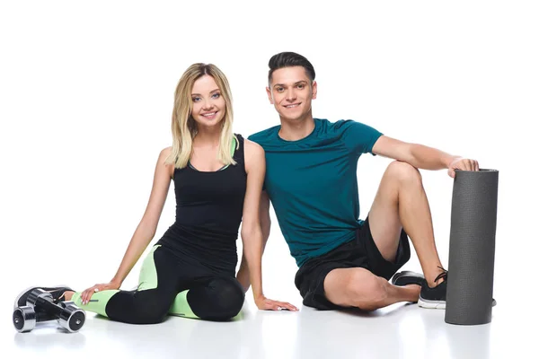 Ajuste jovem casal em sportswear sentado no chão isolado no branco — Fotografia de Stock