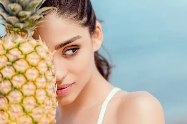 Portrait of beautiful young woman holding fresh pineapple — Stock Photo