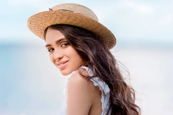 Schöne lächelnde junge Frau posiert mit Strohhut — Stockfoto