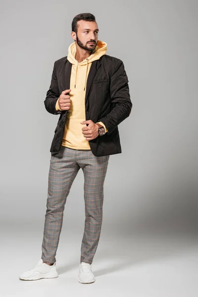 Modelo masculino con estilo en traje de otoño posando sobre fondo gris - foto de stock