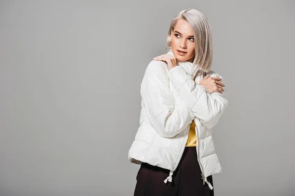Attraktive junge Frau posiert in weißer Jacke isoliert auf grauem Hintergrund — Stockfoto