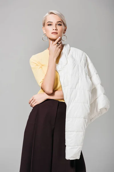 Modelo feminino elegante posando com jaqueta sobre ombro isolado em fundo cinza — Fotografia de Stock