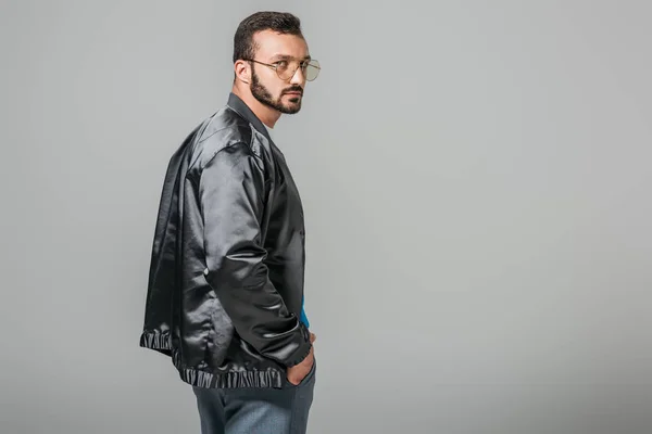 Confident handsome man in stylish black bomber isolated on grey background — Stock Photo