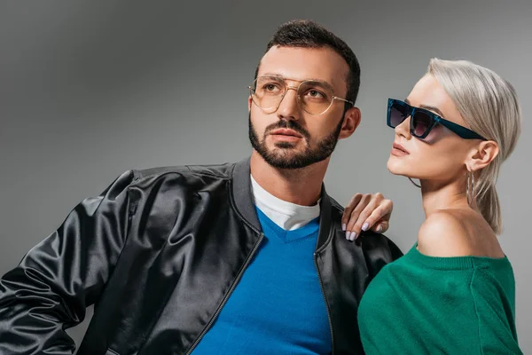 Novio en gafas graduadas y novia en gafas de sol posando para sesión de moda, aislado en gris - foto de stock
