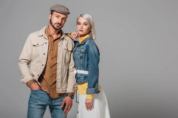 Schönes Modelpaar posiert im Herbst-Outfit, isoliert auf grau — Stockfoto