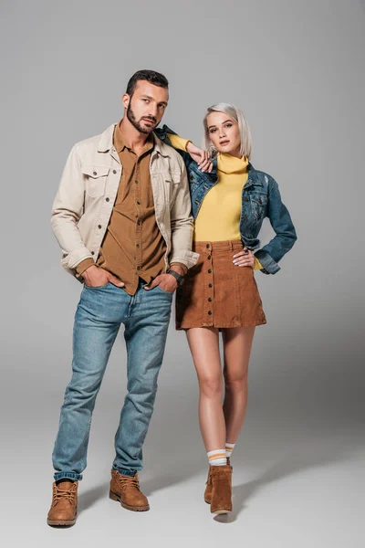 Couple de modèles posant en tenue d'automne de style rue, sur gris — Photo de stock