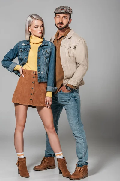 Atractiva pareja posando en traje de otoño para la sesión de moda, en gris — Stock Photo