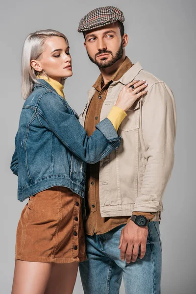 Jeune couple posant en tenue d'automne style rue, isolé sur gris — Photo de stock