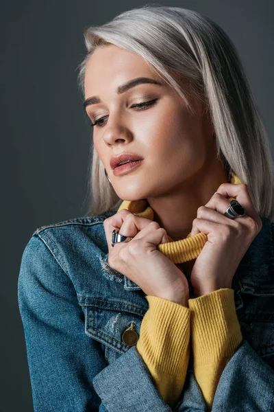 Hermosa mujer en cuello alto amarillo y chaqueta vaquera, aislada en gris - foto de stock