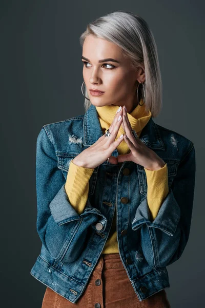 Belle femme à col roulé jaune élégant et veste en jean, isolé sur gris — Photo de stock