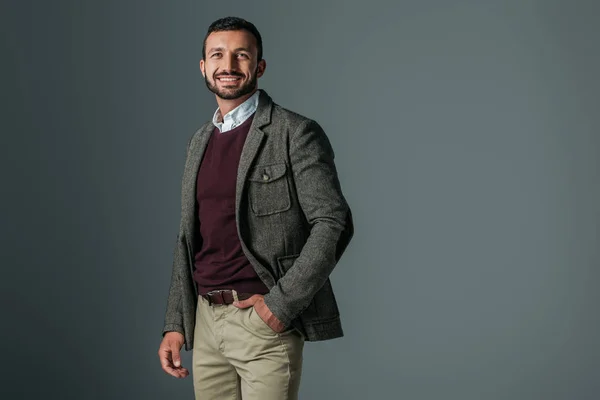 Bello uomo sorridente in posa giacca di tweed, isolato su grigio — Foto stock