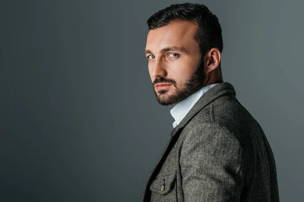 Apuesto hombre confiado posando en chaqueta de tweed, aislado en gris - foto de stock