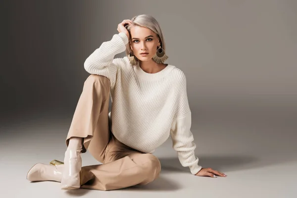 Elegante bella ragazza in posa in maglione bianco e tacchi autunnali, su grigio — Foto stock