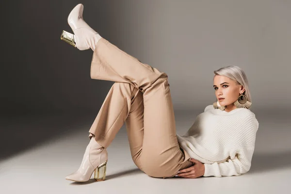 Séduisante femme élégante posant en tenue d'automne et talons, sur gris — Photo de stock