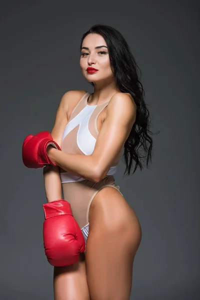 Portrait of sexy sportive woman in white leotard and boxing gloves isolated on grey — Stock Photo