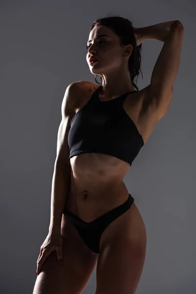 Femme sexy en soutien-gorge de sport et culotte posant isolé sur gris — Photo de stock