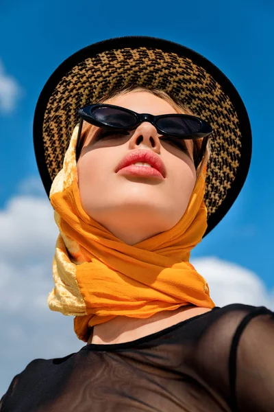 Bottom view of stylish girl in trendy sunglasses and hat — Stock Photo