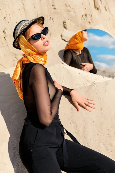 Mulher na moda em óculos de sol na moda posando com espelho na duna de areia — Fotografia de Stock