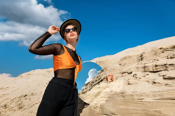 Modelo elegante posando com espelho redondo perto de duna — Fotografia de Stock