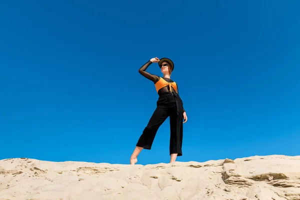 Bela jovem mulher posando em roupas da moda com céu azul no fundo — Fotografia de Stock