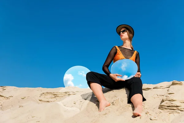 Attraktive Frau posiert mit runden Spiegeln mit Spiegelung des blauen Himmels — Stockfoto