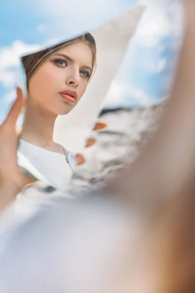 Bela menina elegante segurando pedaço de espelho e olhando em seu reflexo — Fotografia de Stock