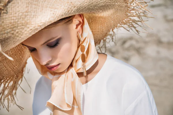 Hermosa chica tierna posando en bufanda de seda y sombrero de paja - foto de stock