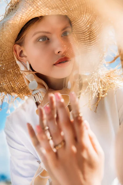 Mirror with reflection of beautiful girl in trendy straw hat — Stock Photo