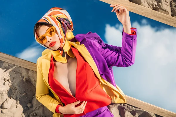 Top view of elegant fashionable lady posing on mirror with reflection of blue sky — Stock Photo