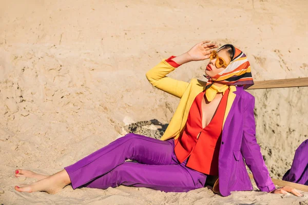 Menina bonita em roupas elegantes coloridas sentado na areia com espelho — Fotografia de Stock