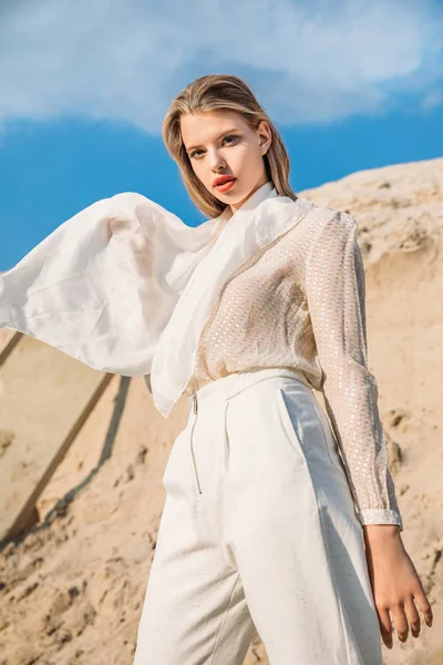 Séduisant modèle blond avec écharpe en soie blanche posant dans le désert — Photo de stock