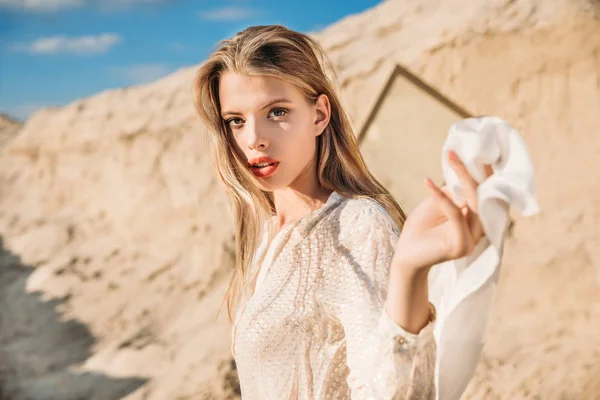 Atractiva chica rubia con bufanda de seda blanca caminando en la duna de arena - foto de stock