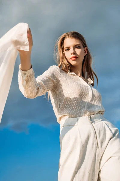 Menina atraente elegante em roupas brancas com cachecol, com céu nublado azul — Fotografia de Stock