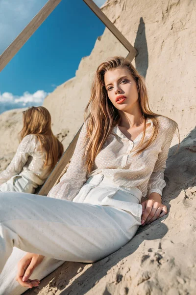 Belle femme à la mode posant en vêtements blancs près du miroir — Photo de stock