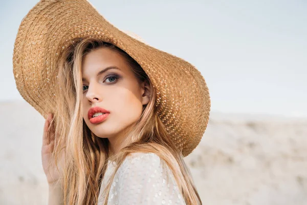 Привлекательная блондинка позирует в модной соломенной шляпе — стоковое фото