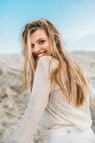 Jeune femme blonde souriante en vêtements blancs posant pour le tournage de mode — Photo de stock