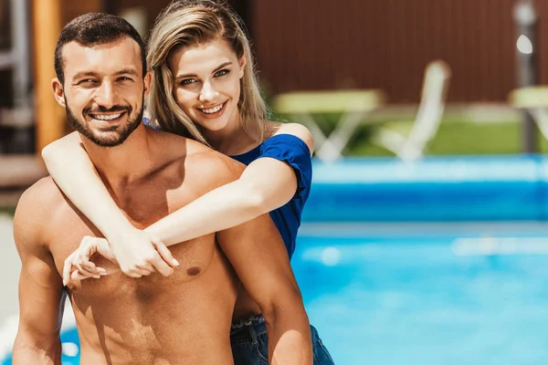 Красива усміхнена пара обіймає біля басейну — стокове фото