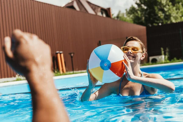 Mulher feliz jogando com bola de praia na piscina — Fotografia de Stock
