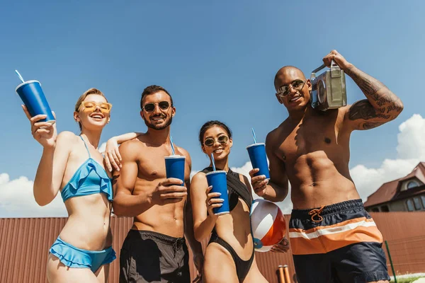 Personnes multiculturelles gaies avec des boissons et boombox rétro — Photo de stock