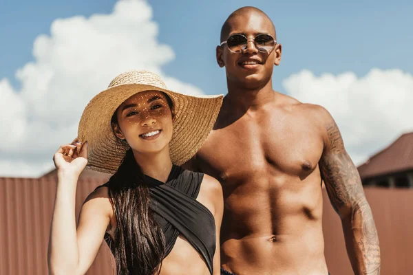 Asiatique fille en paille chapeau et afro-américain copain dans lunettes de soleil — Photo de stock