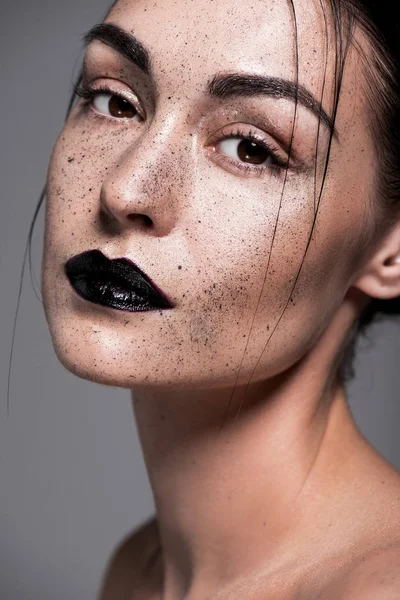 Fille à la mode avec des lèvres noires et des taches de rousseur sur le visage, isolé sur gris — Photo de stock