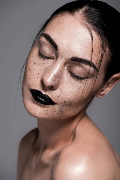 Portrait of beautiful girl with closed eyes, black lips and freckles, isolated on grey — Stock Photo